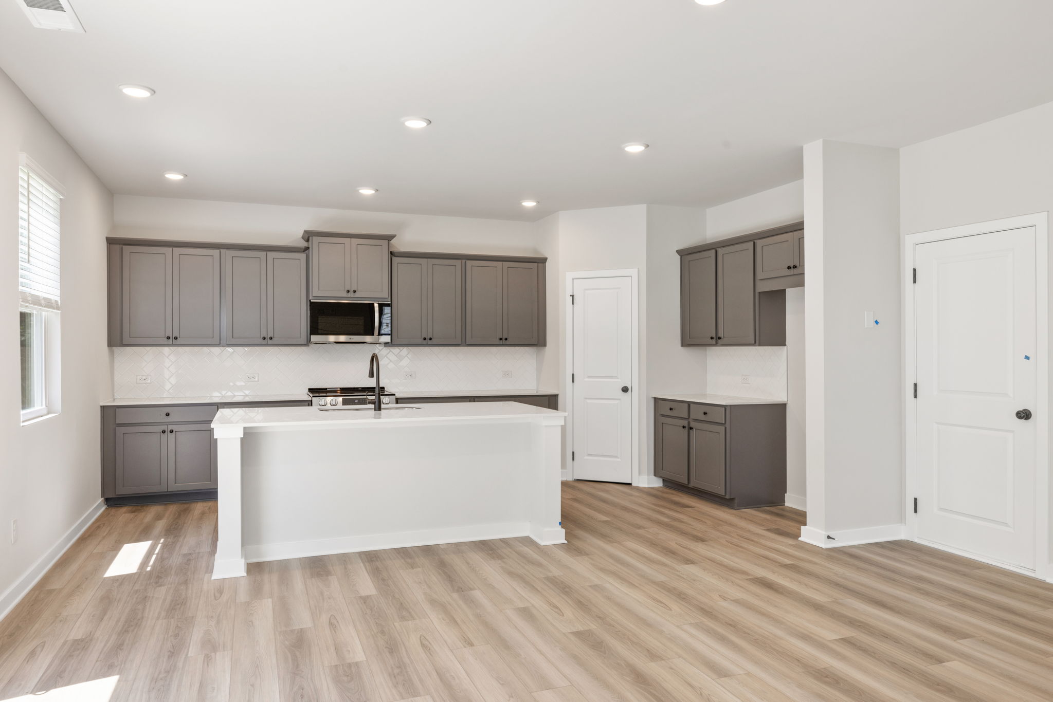A kitchen with white cabinets.