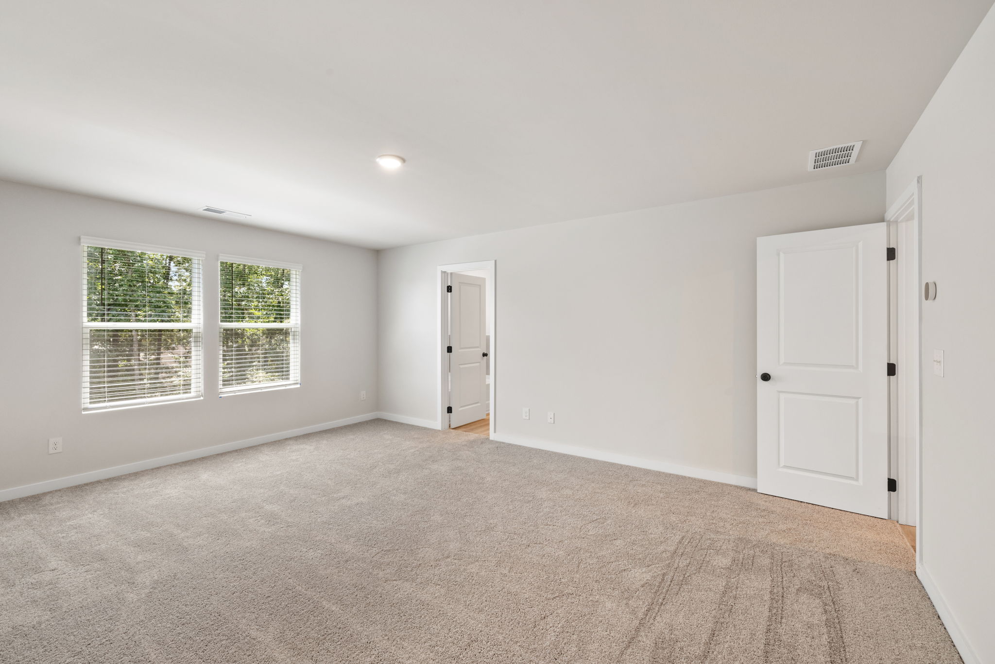 A room with white walls and a carpeted floor.
