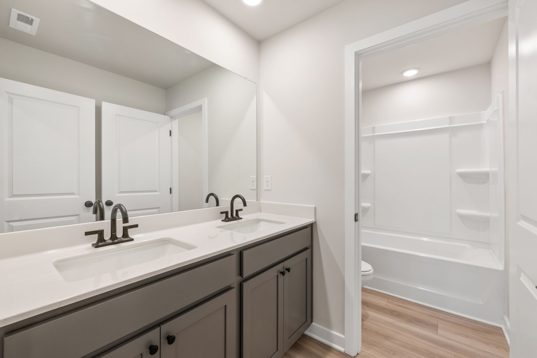 A bathroom with a tub sink and a shower.