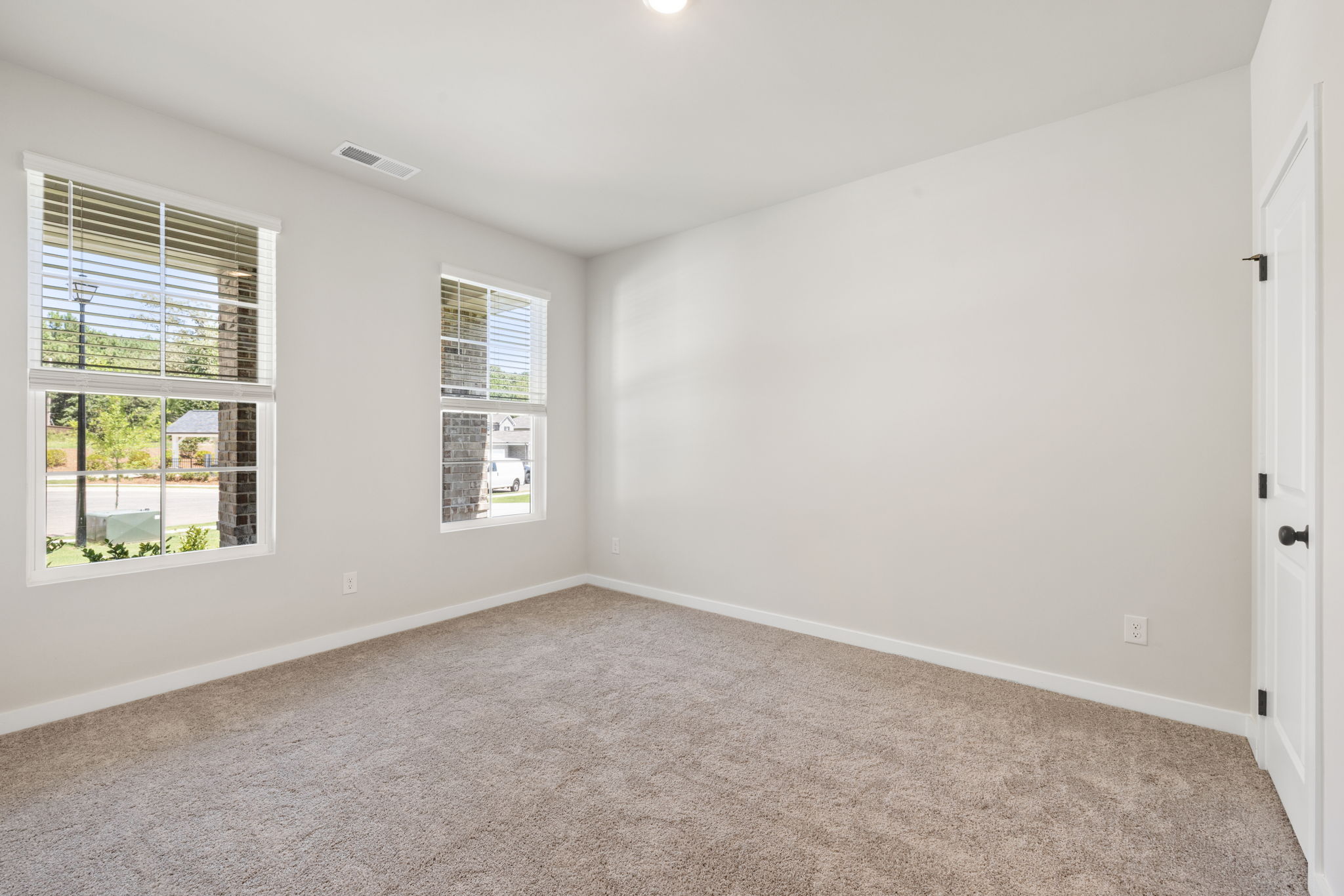 A room with a carpet and windows.