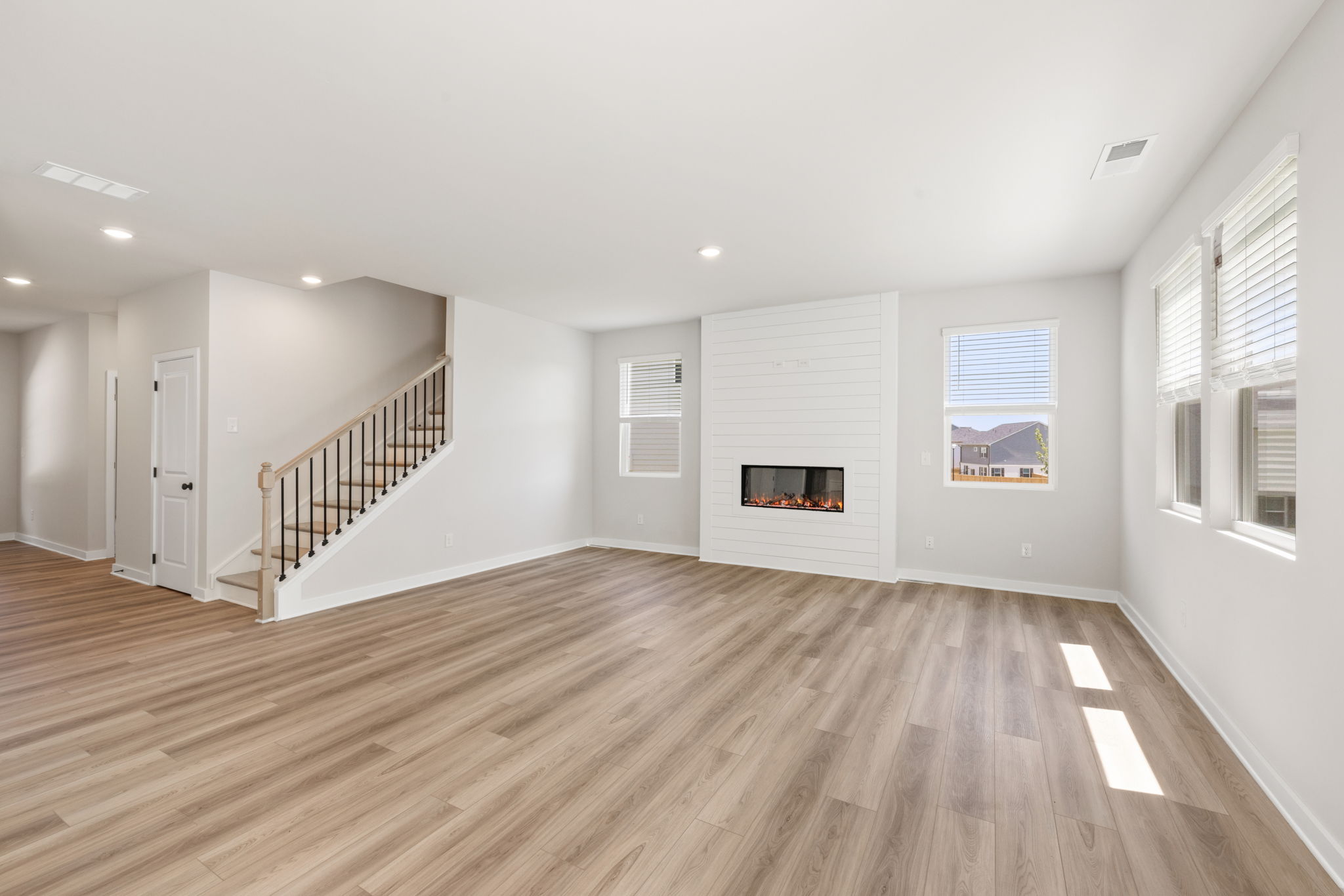 A room with a wood floor and a staircase.