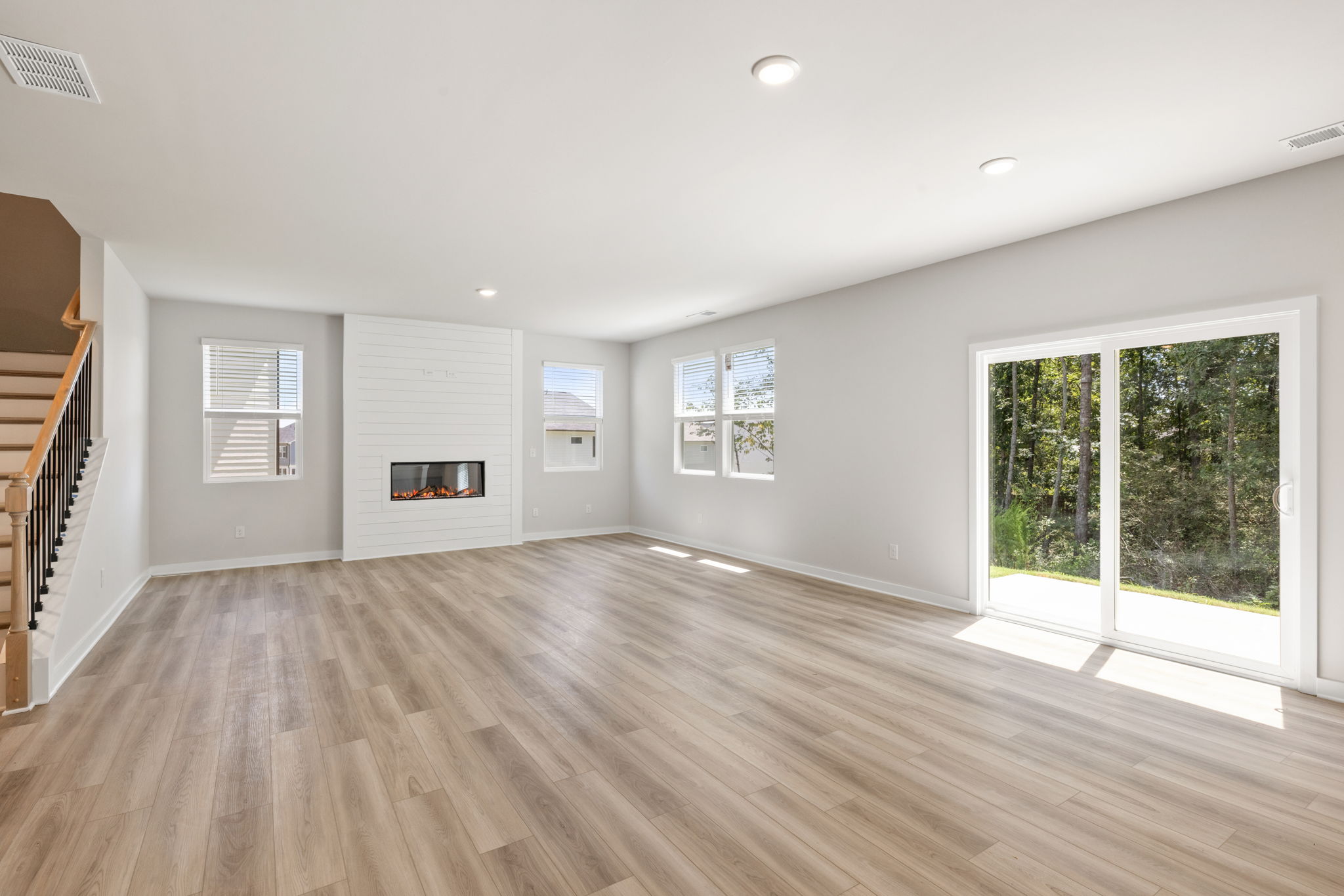 A large empty room with a wood floor and a wood floor.