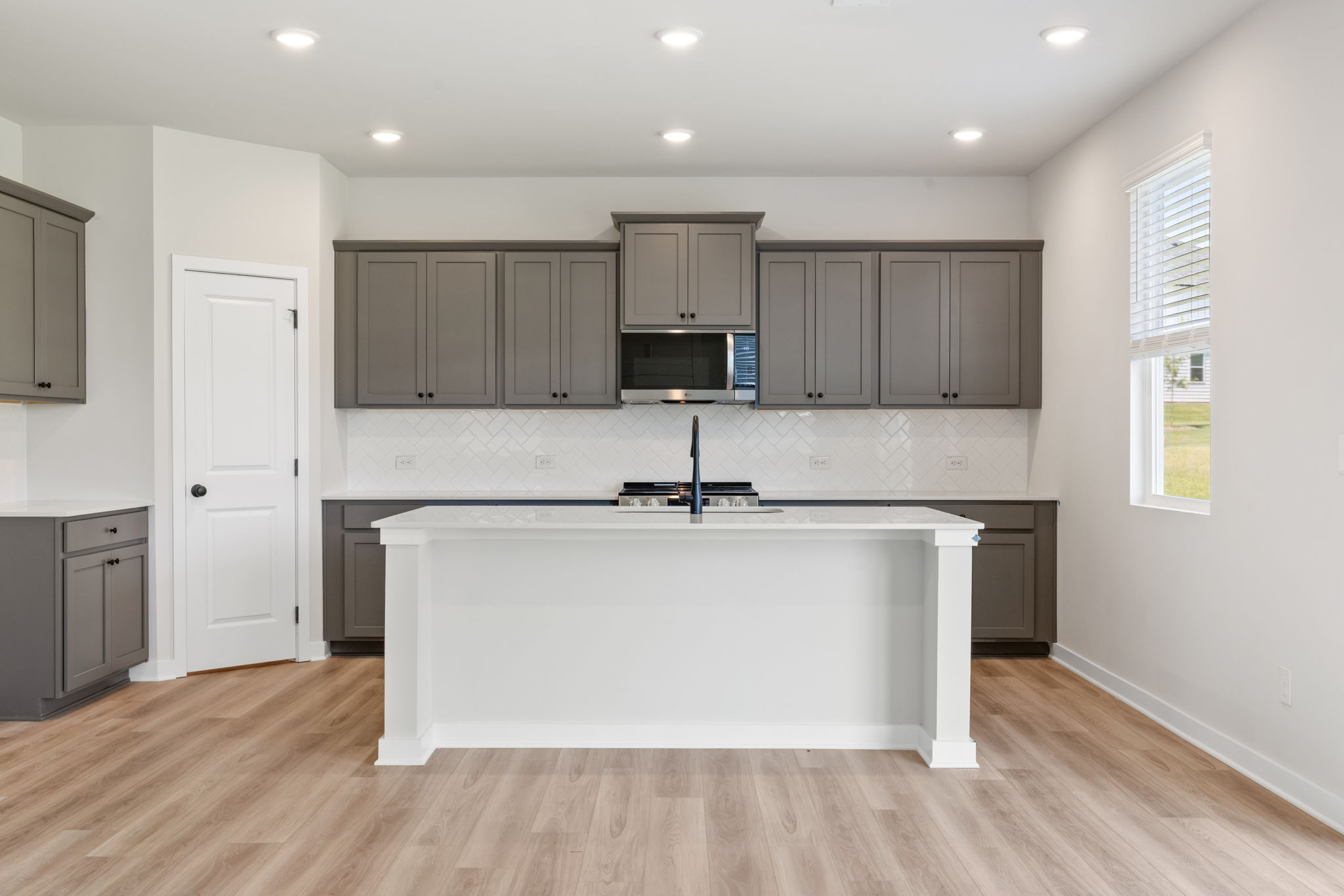 A kitchen with white cabinets.