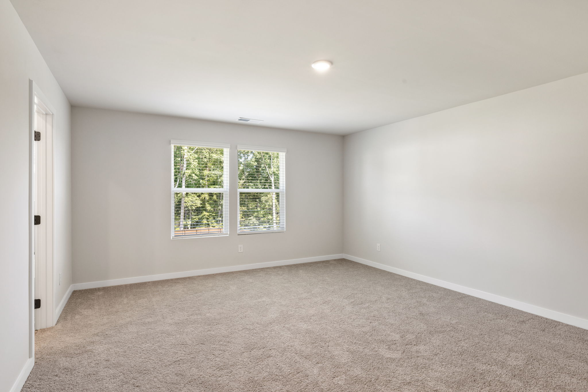 A room with a window and a carpet.