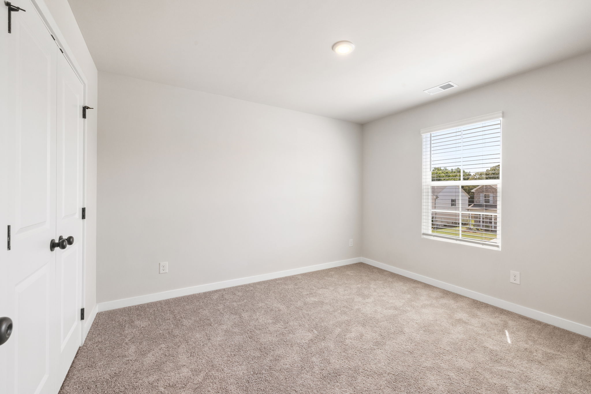 A room with a carpet and a window.