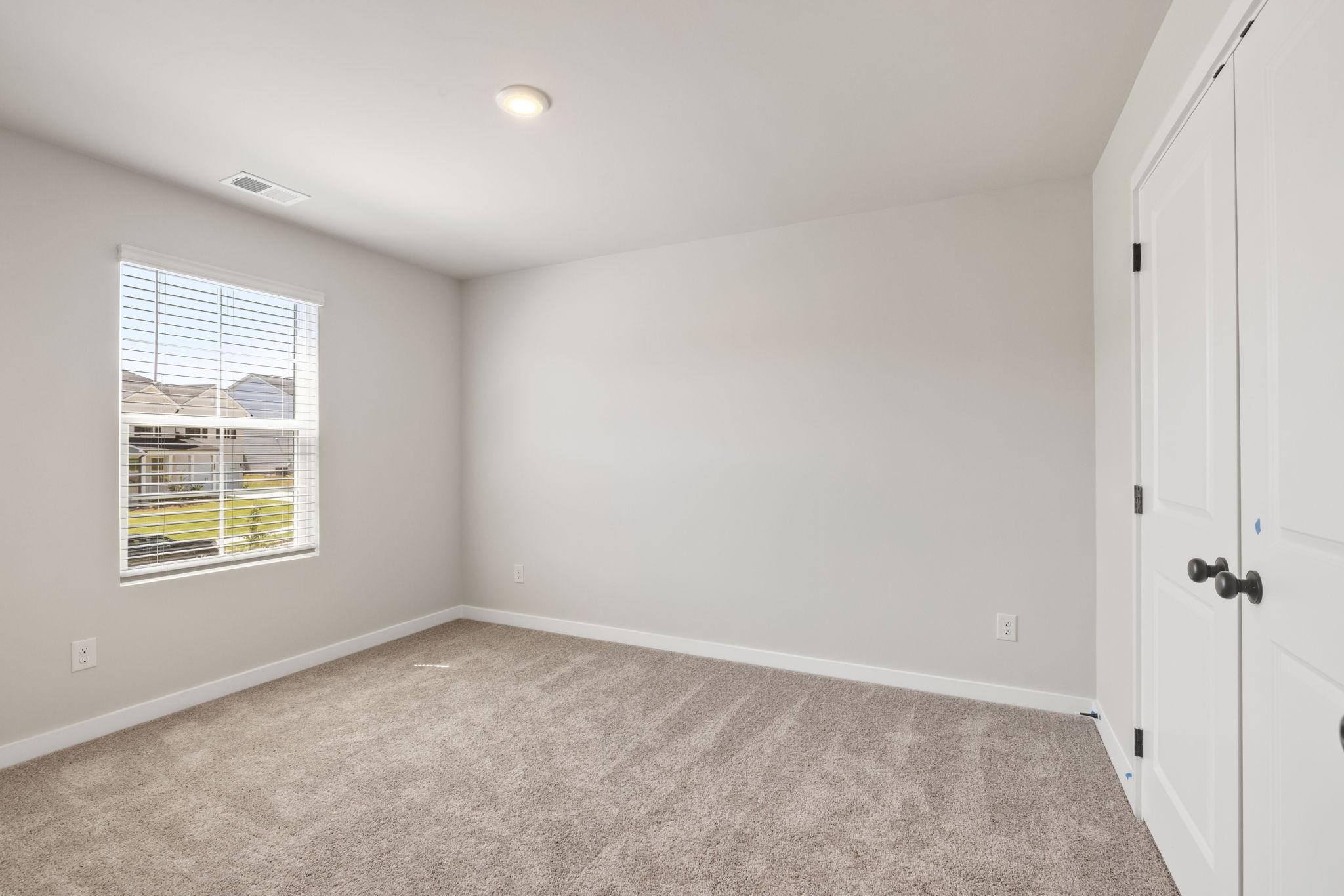 A room with a window and a carpet.