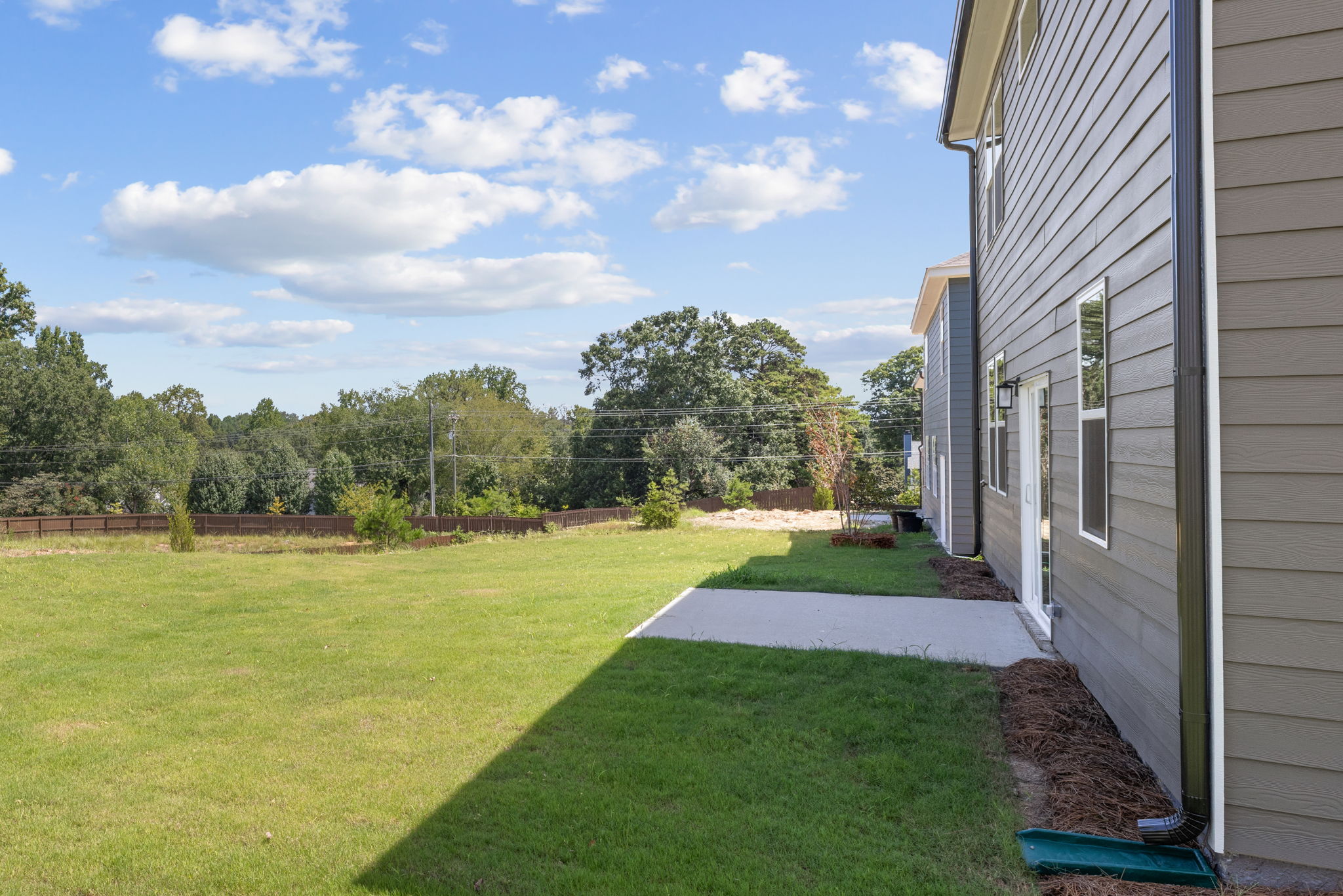 A backyard with a house and trees.