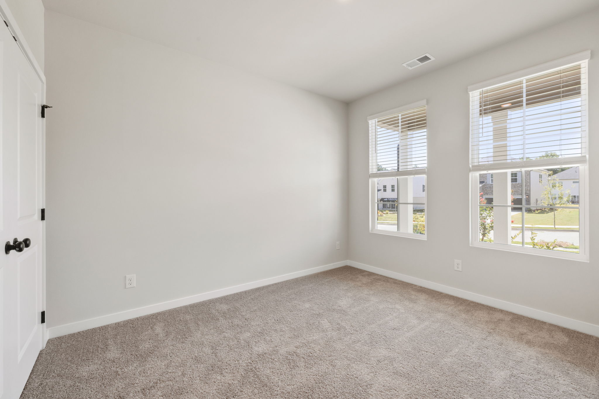 A room with windows and a carpet.