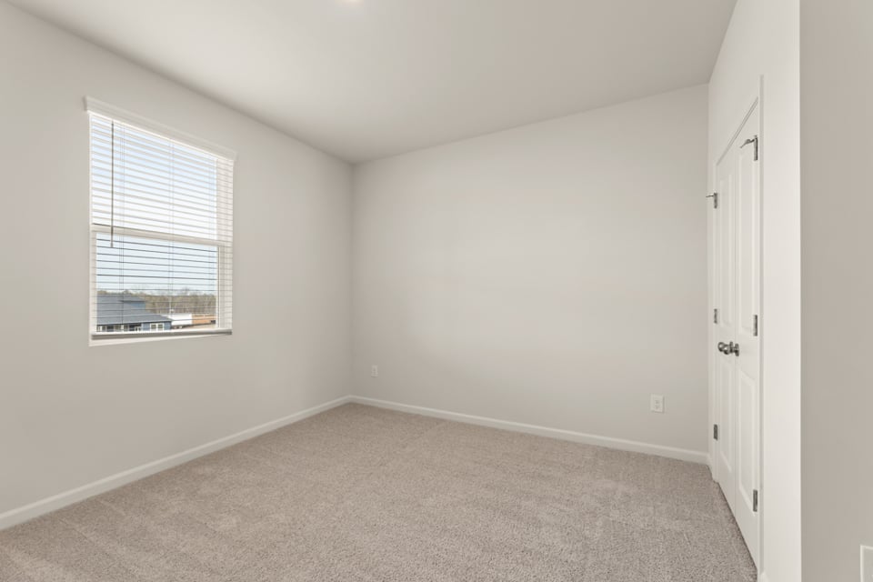 A room with a window and a carpet.