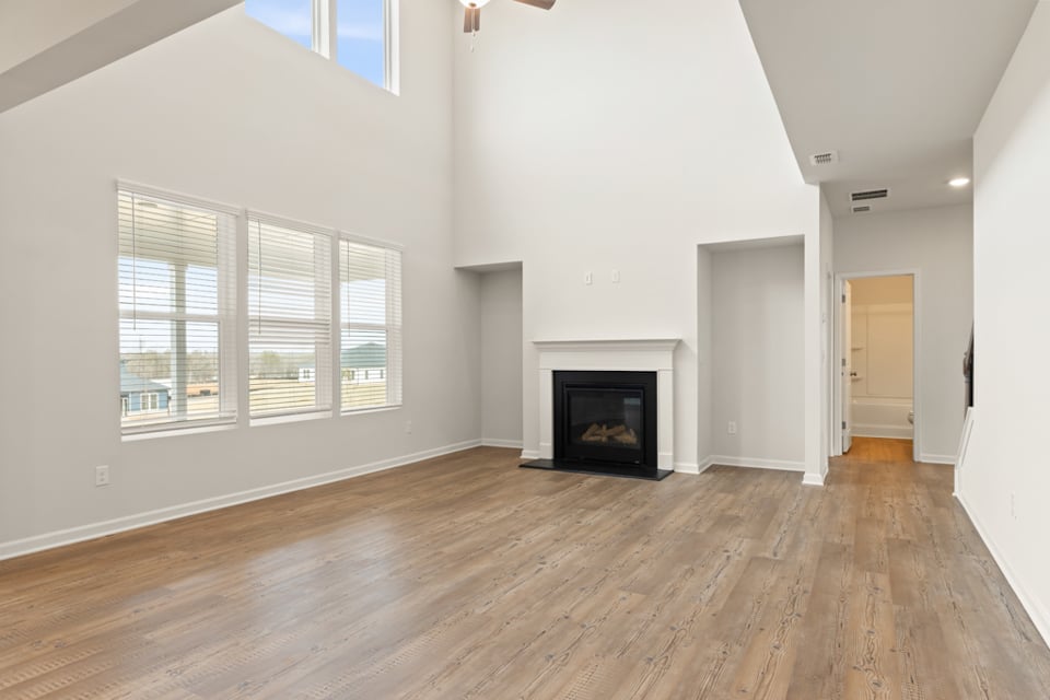 A room with a fireplace and wood floors.