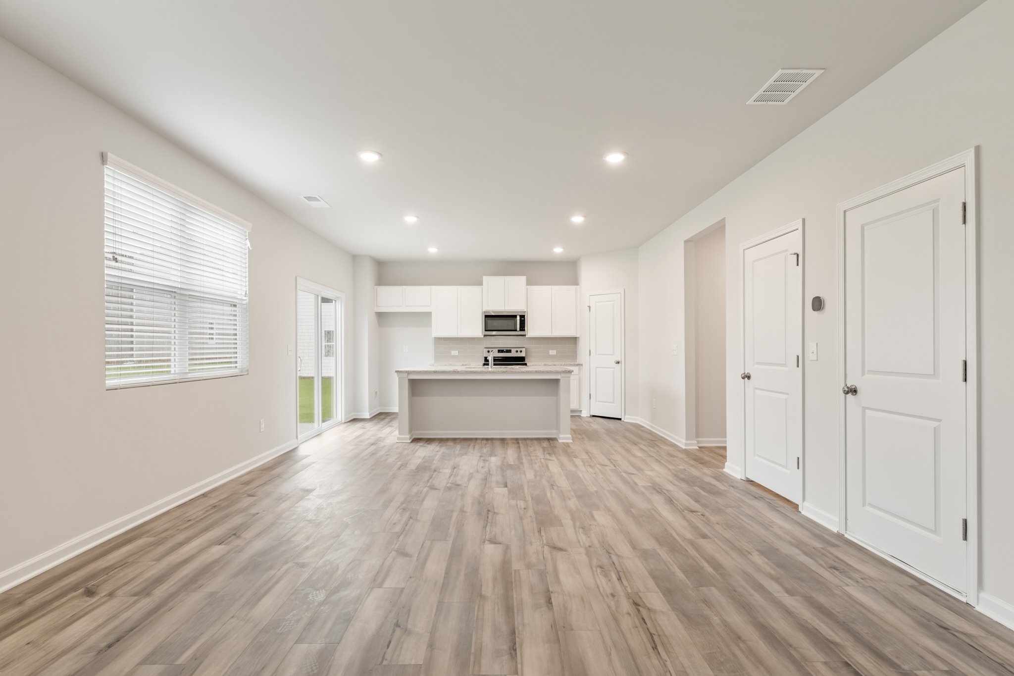 A large empty room with white cabinets.