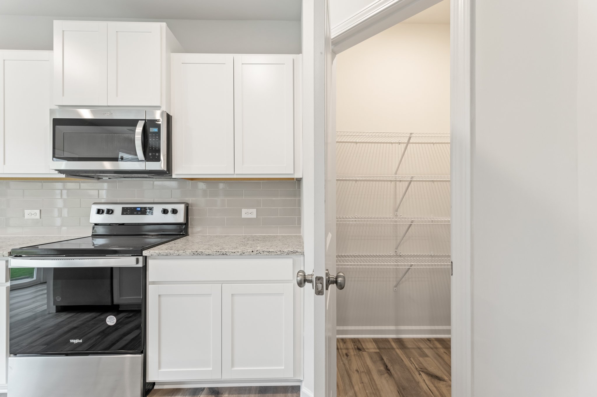 A kitchen with white cabinets.