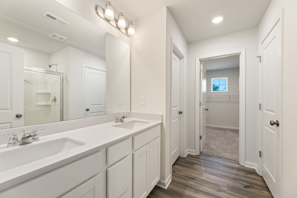 A bathroom with white cabinets.