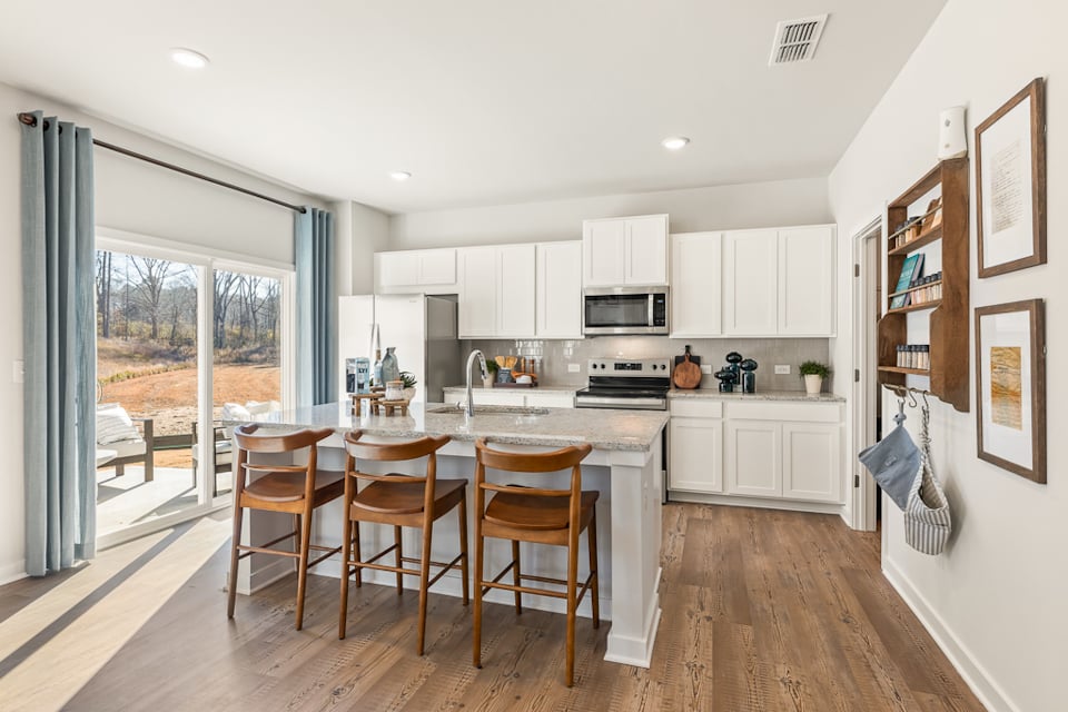 A kitchen with a dining table and chairs.