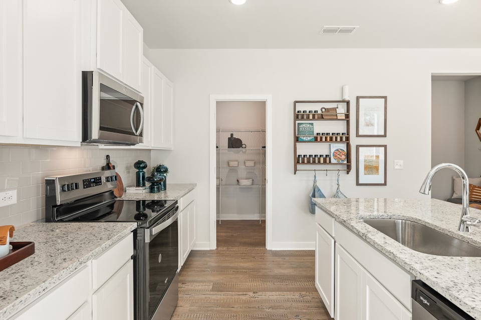 A kitchen with white cabinets.