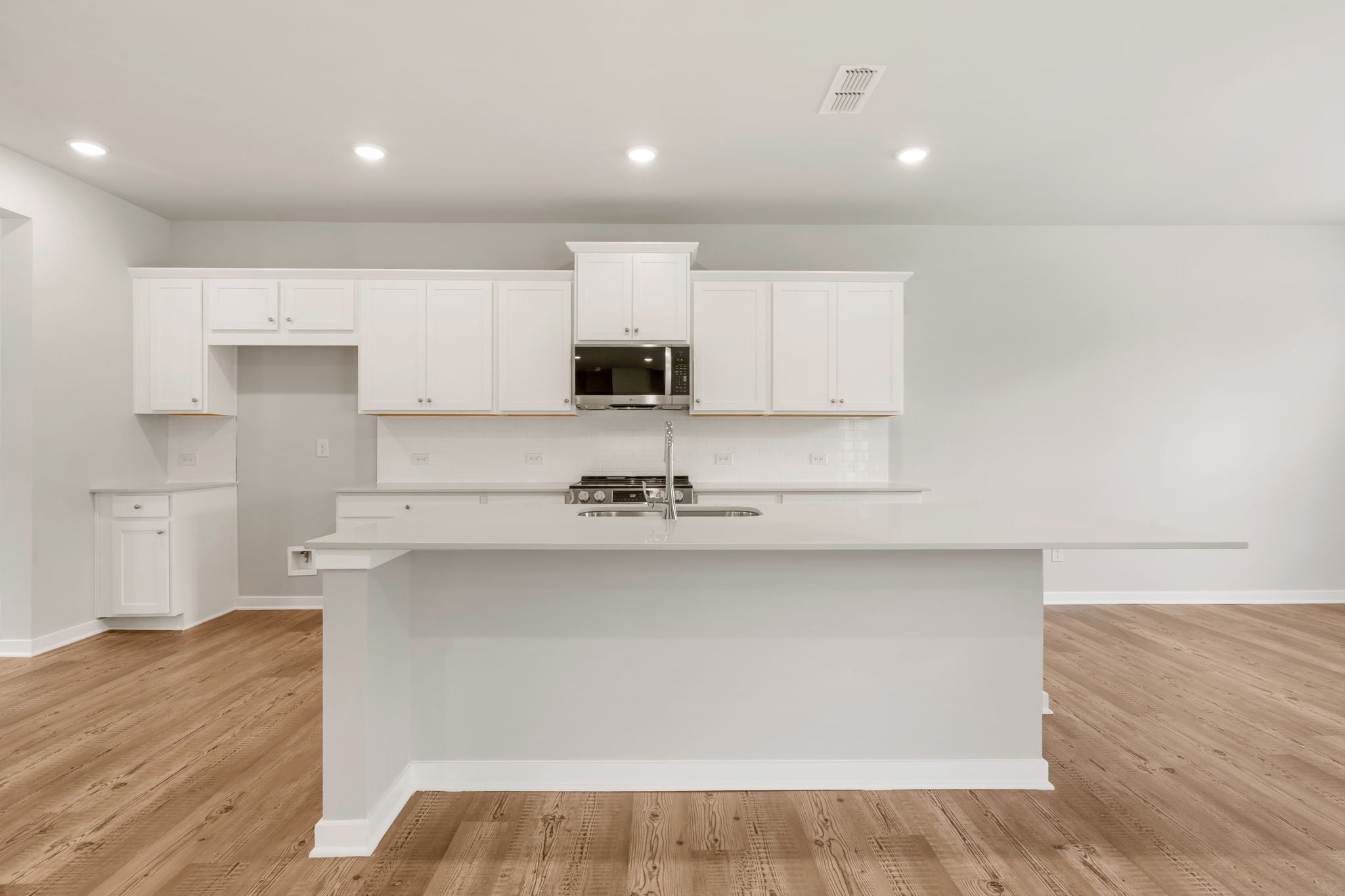 A kitchen with white cabinets.