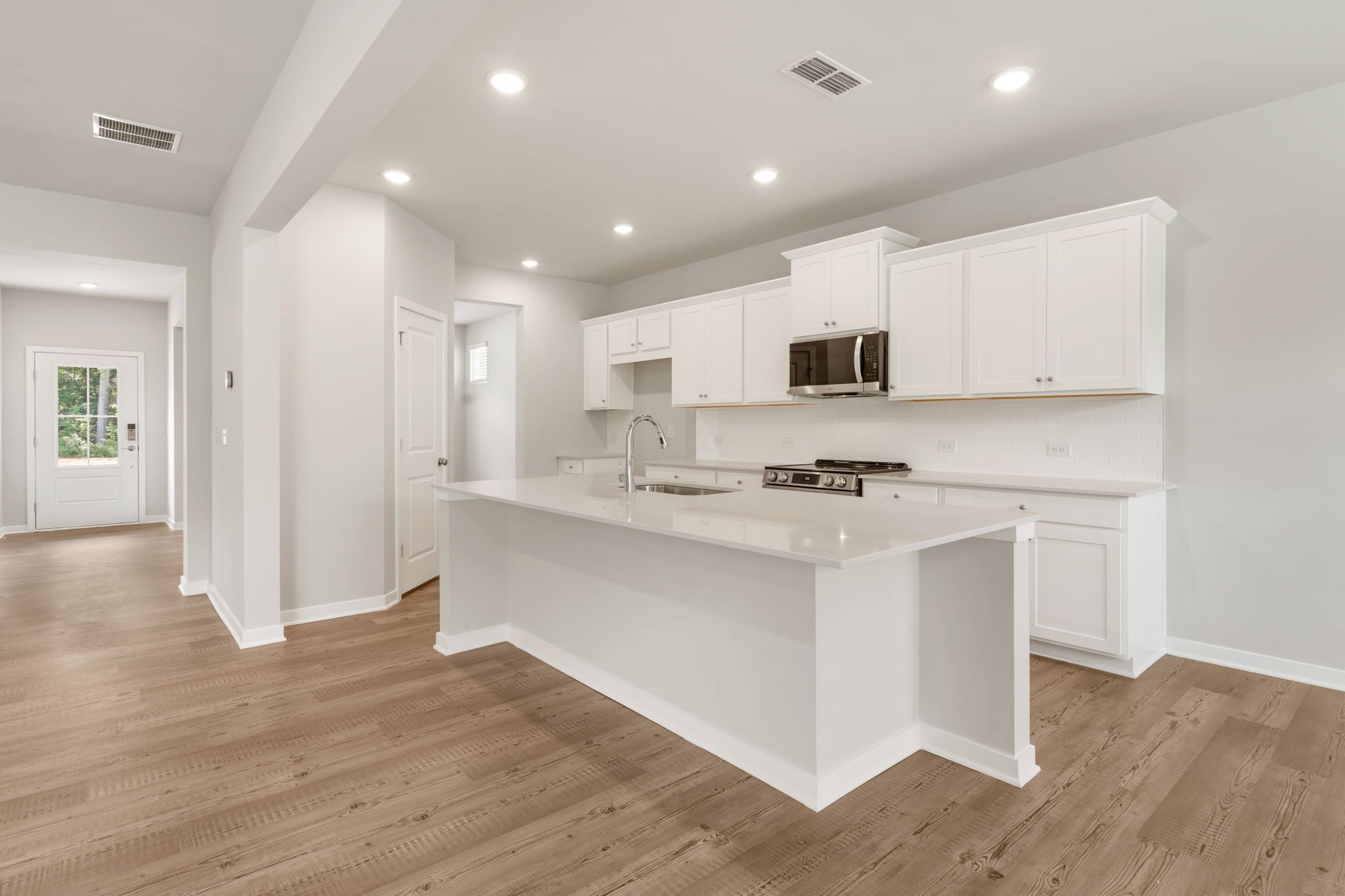 A kitchen with white cabinets.