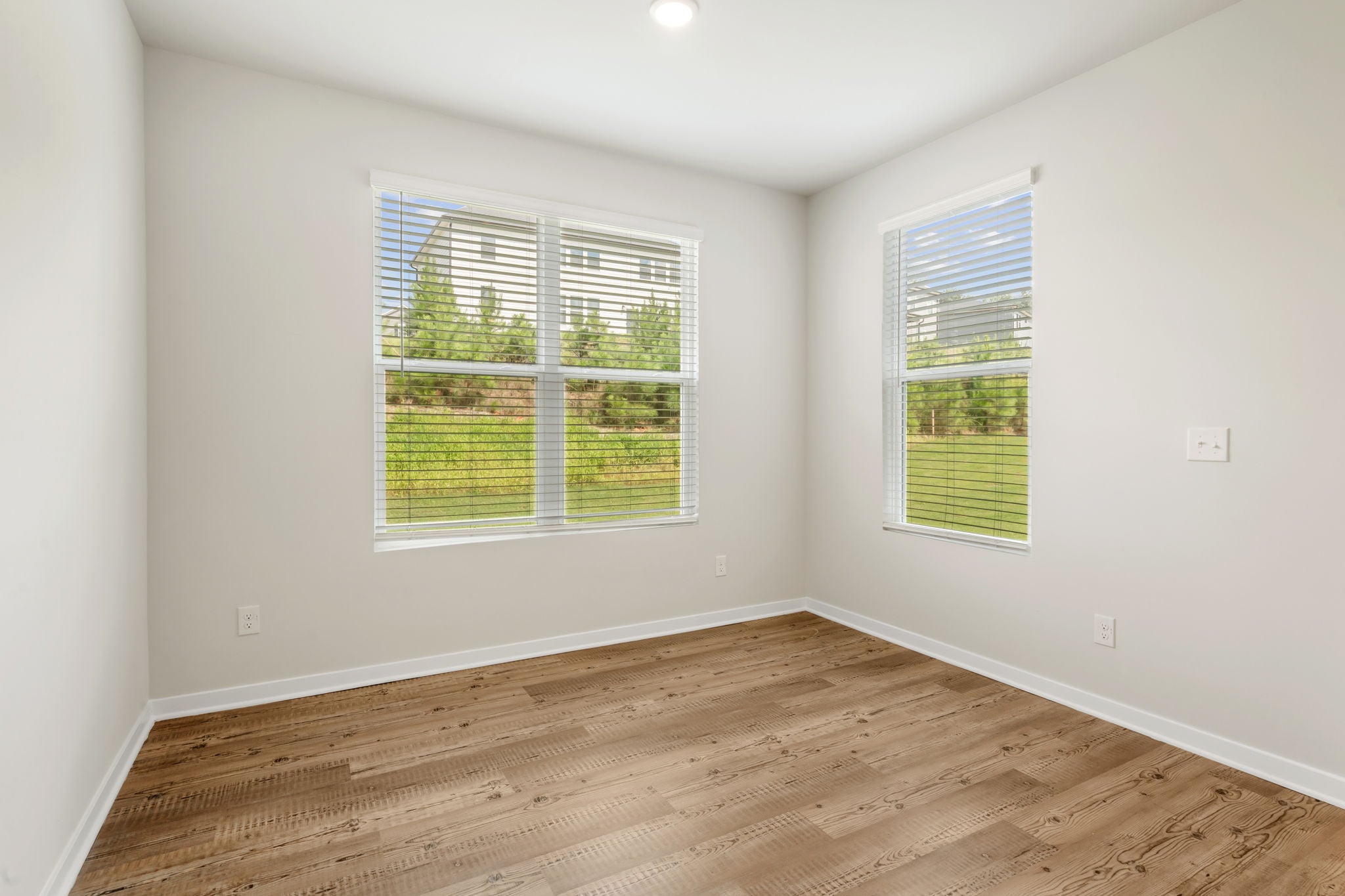 A room with windows and wood floor.