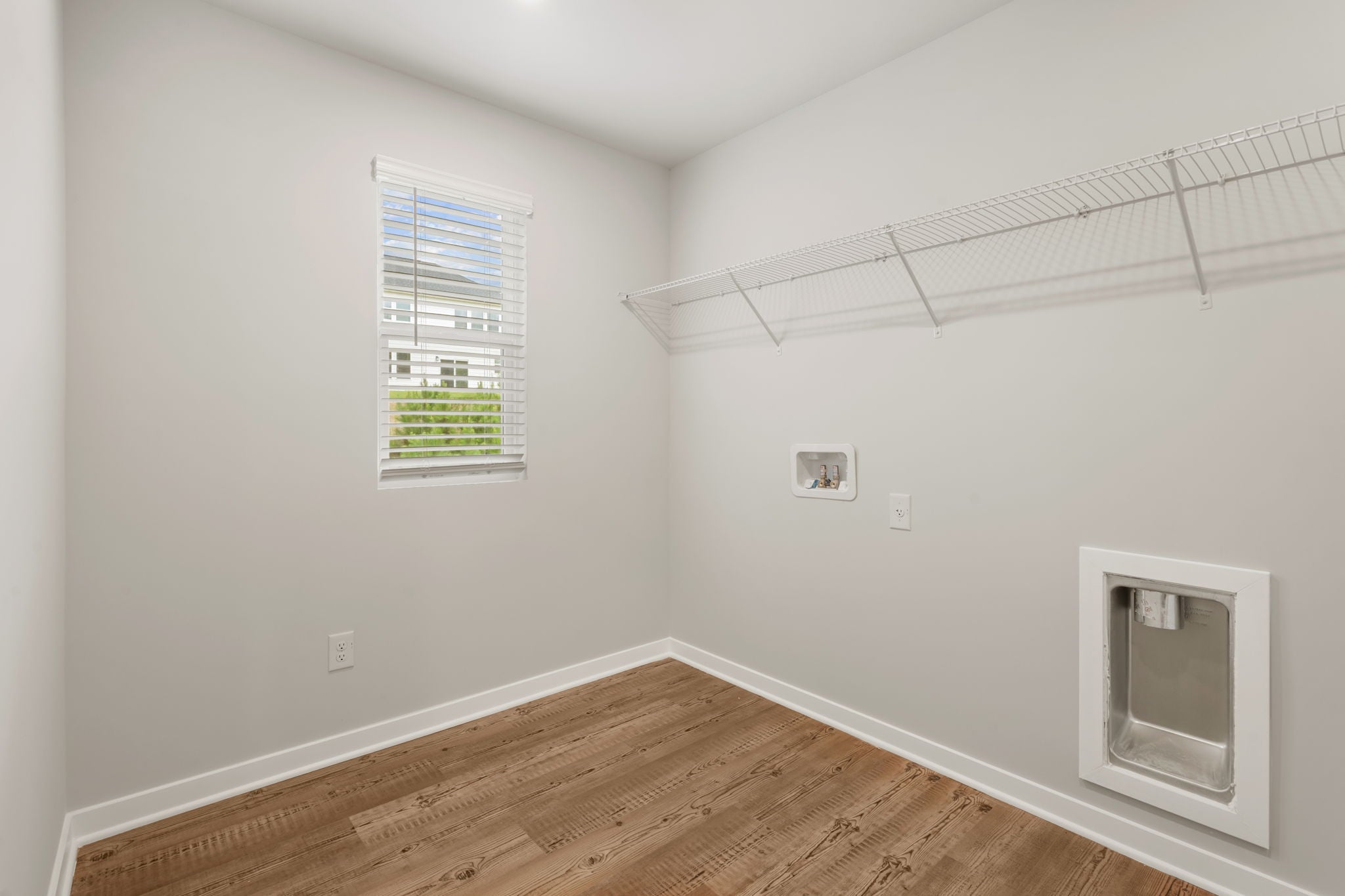 A room with a wood floor and a window.