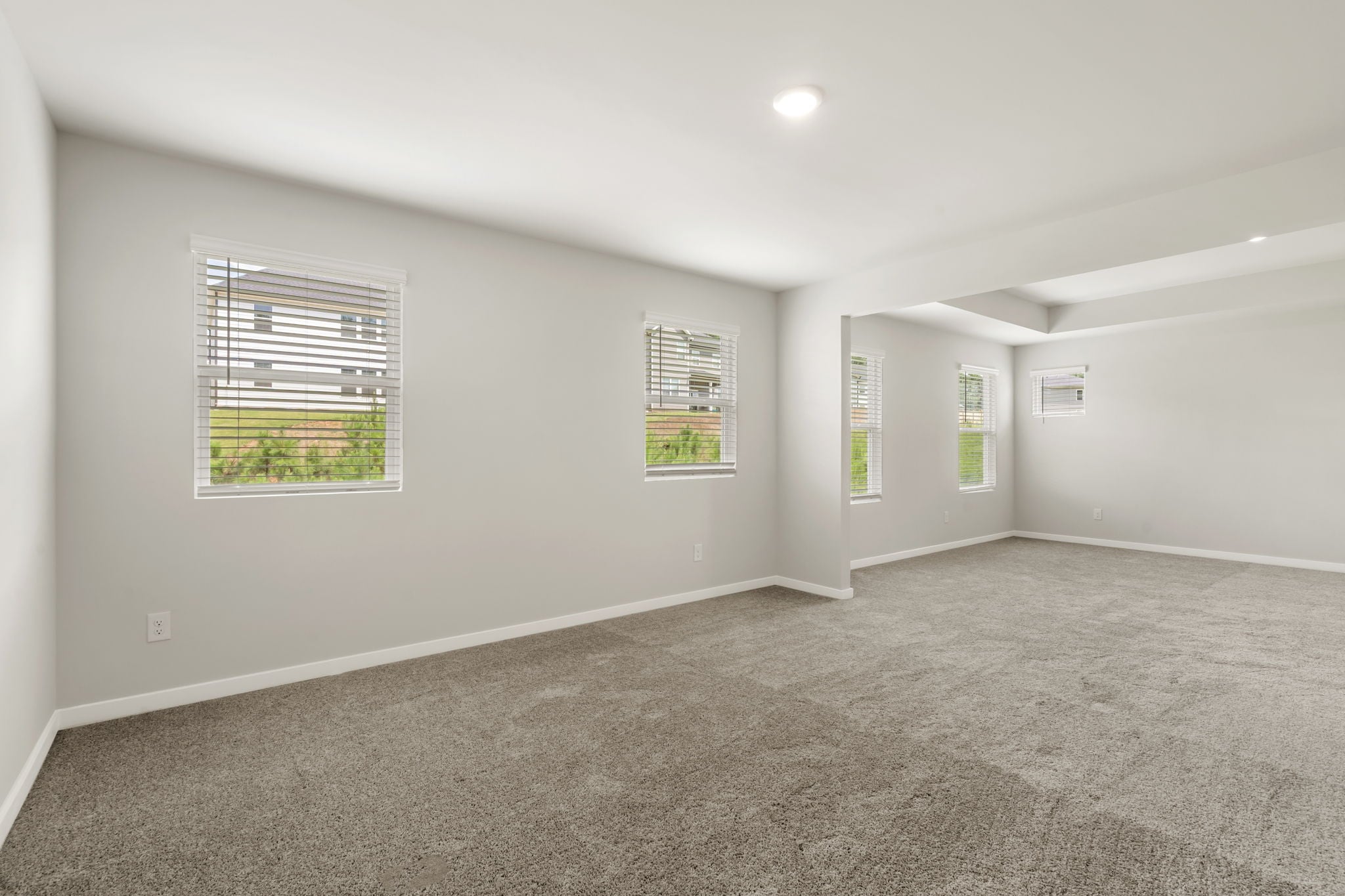 A room with a carpet and a window.