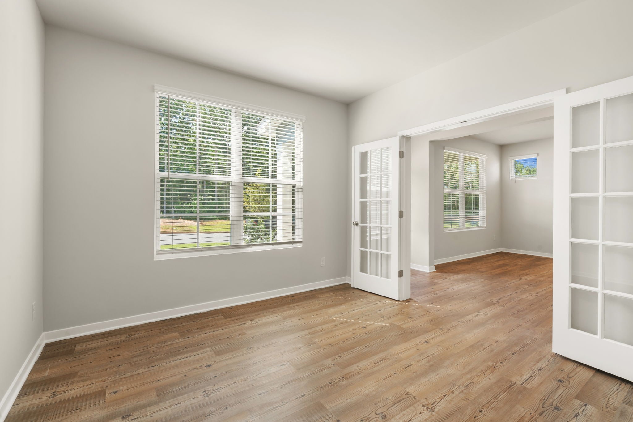 A room with a wood floor and windows.