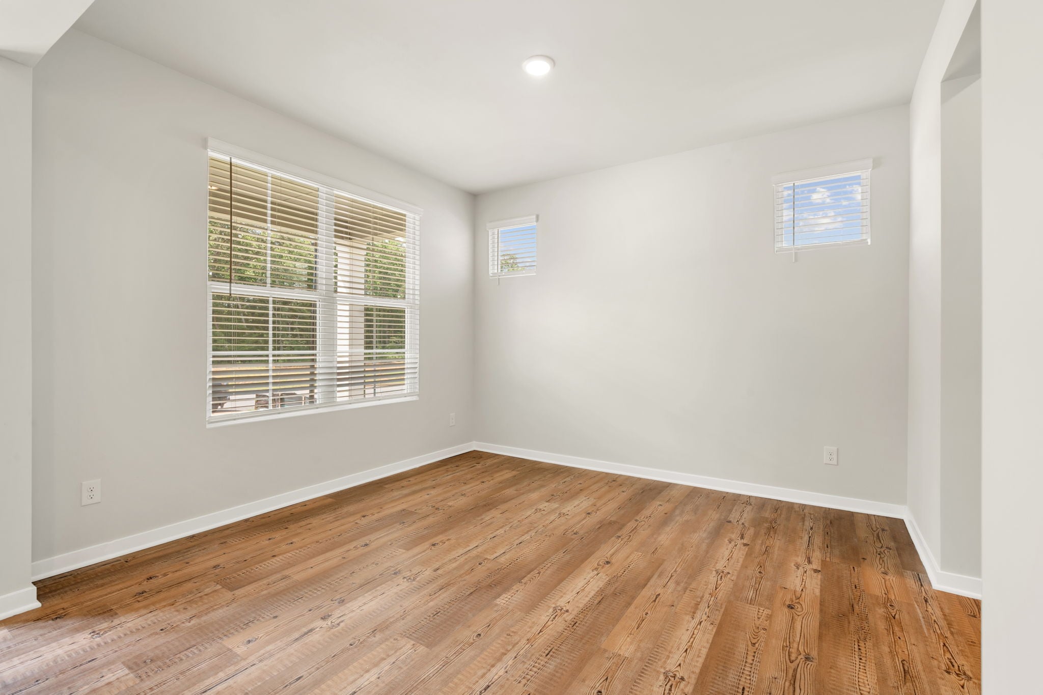 A room with a wood floor and a window.