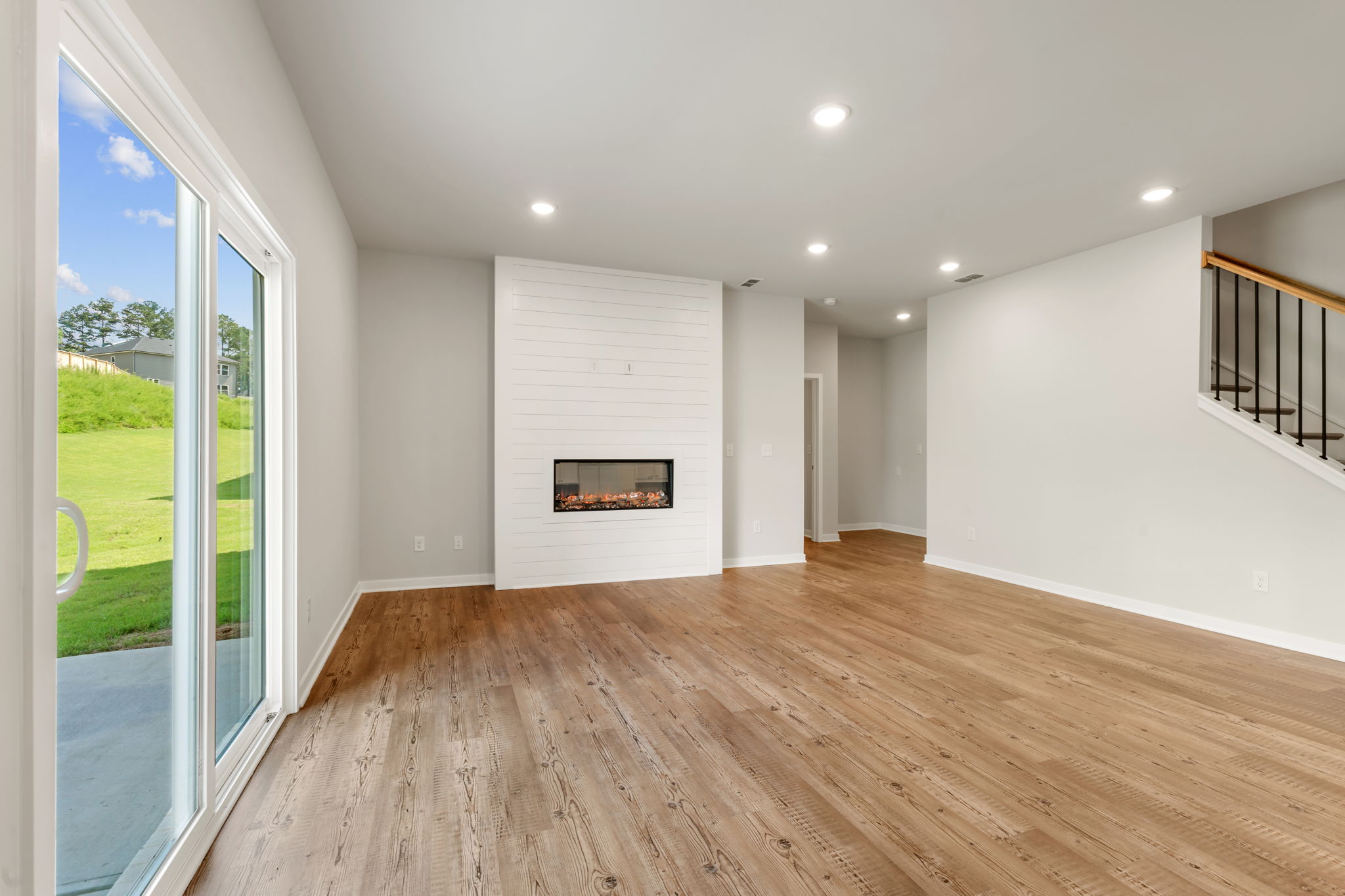 A room with a wood floor and a wood floor with a glass door.