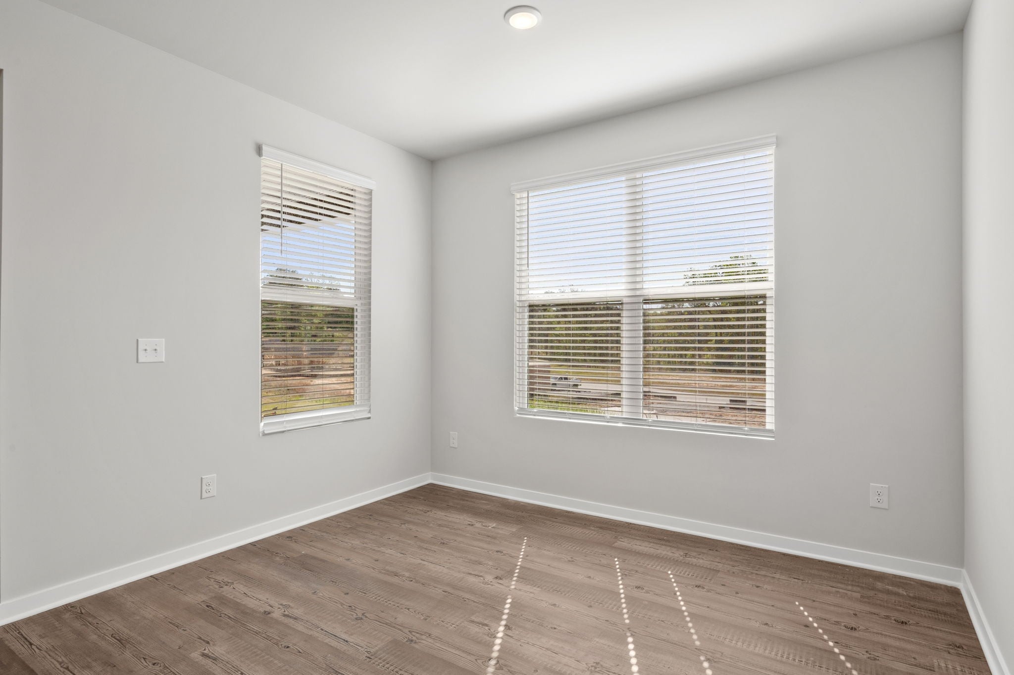A room with a wood floor and windows.