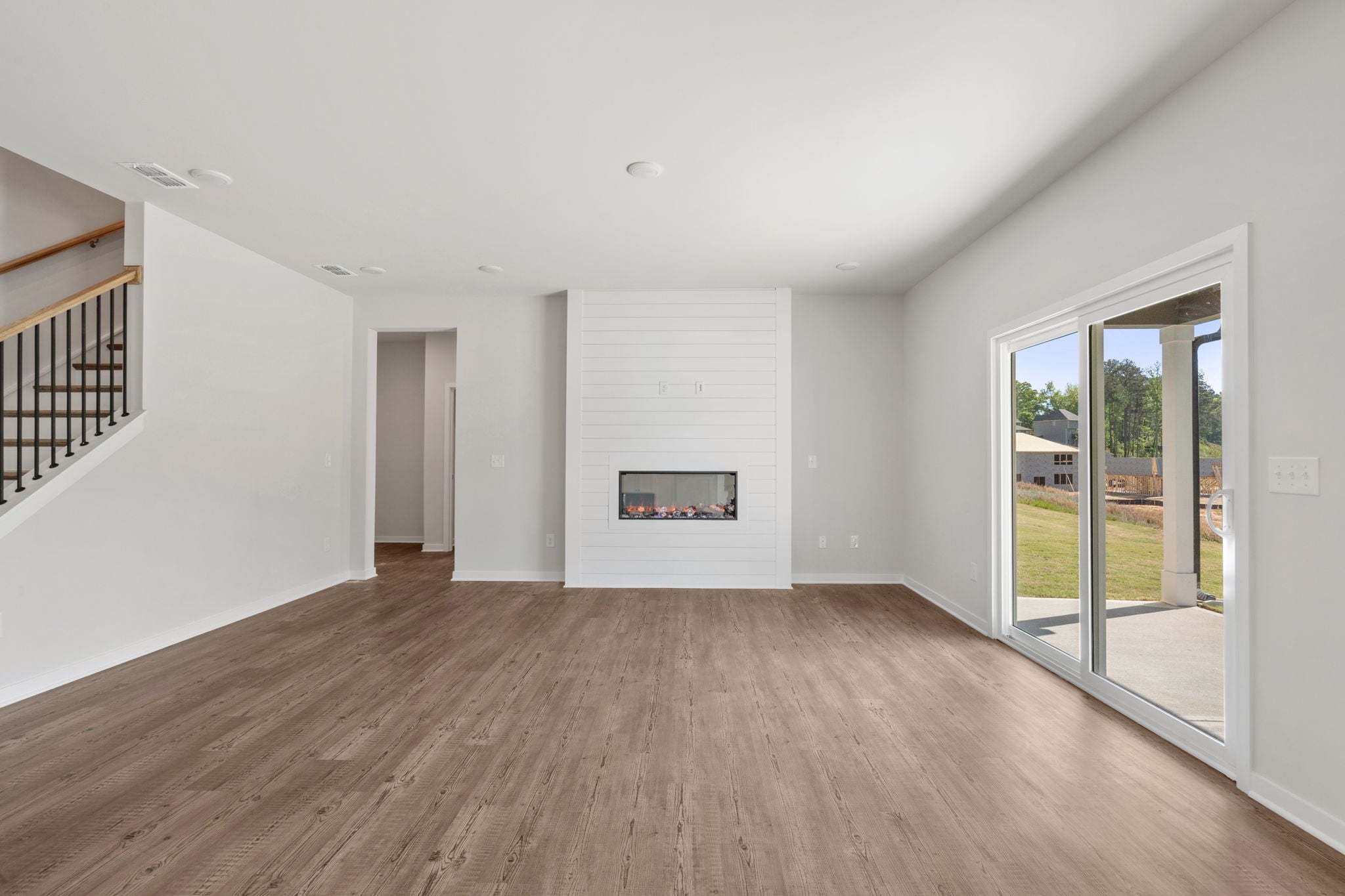 A room with a wood floor and a fireplace.