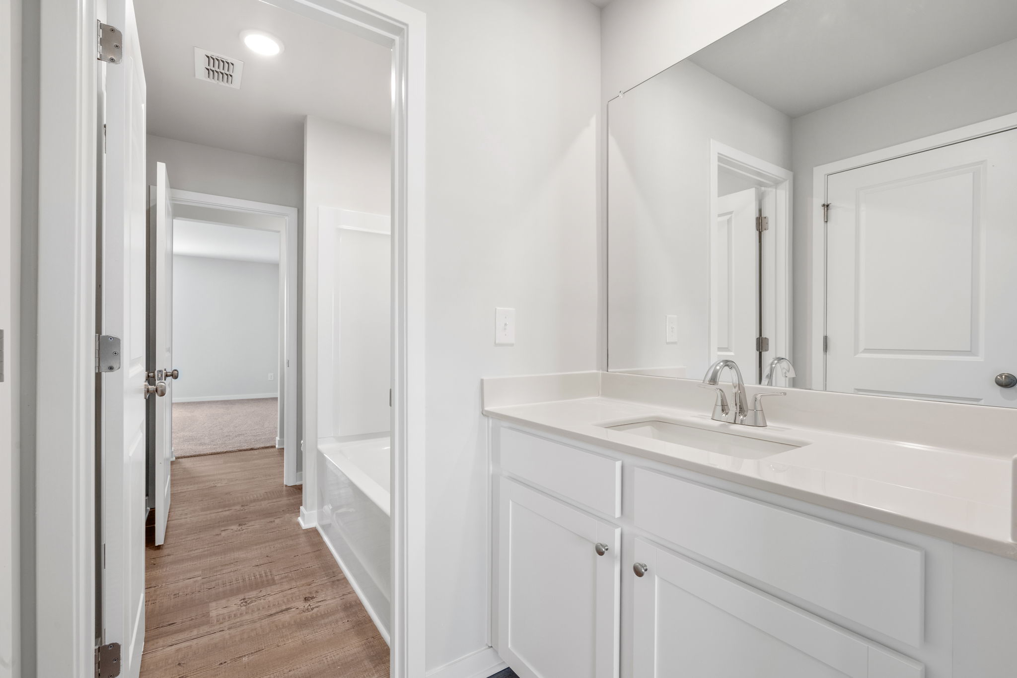 A bathroom with white cabinets.