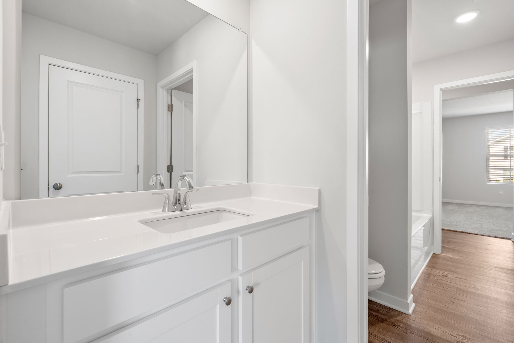 A bathroom with white cabinets.