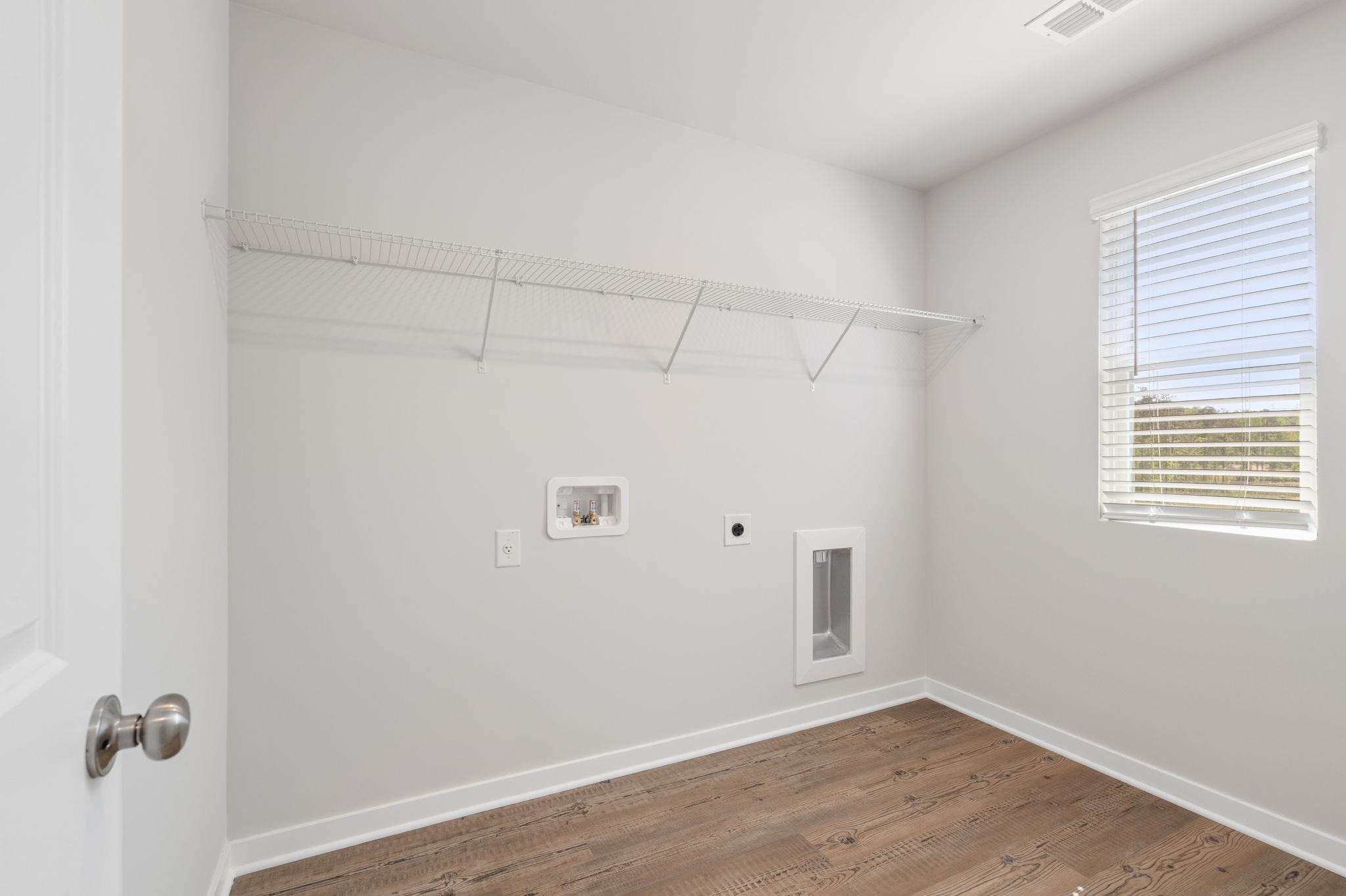 A room with a wood floor and white walls.