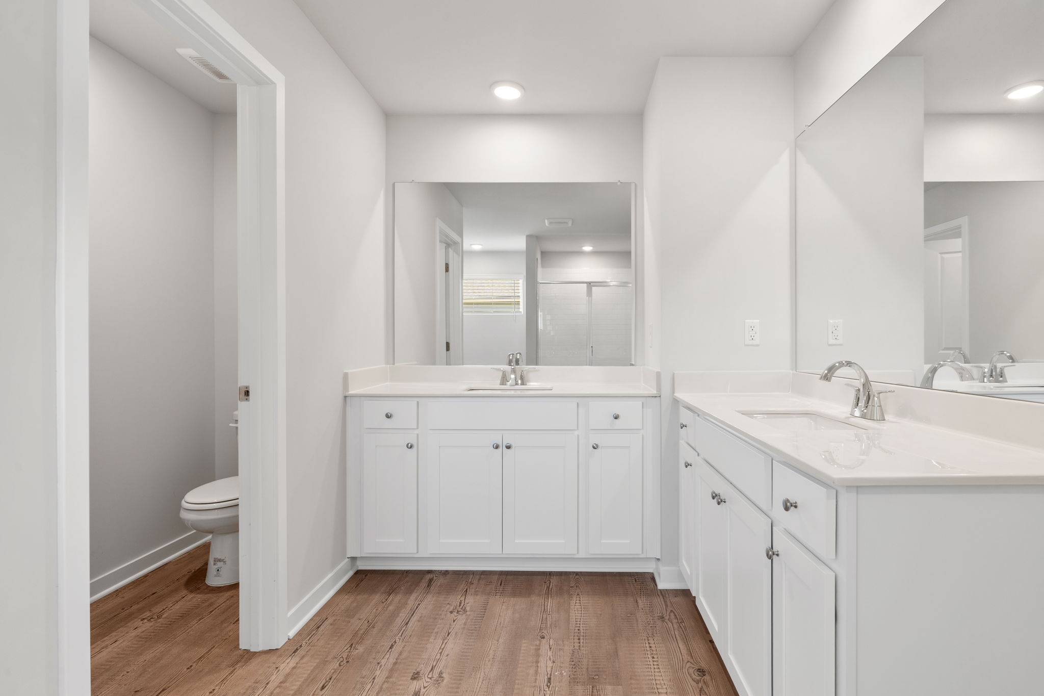 A bathroom with white cabinets.