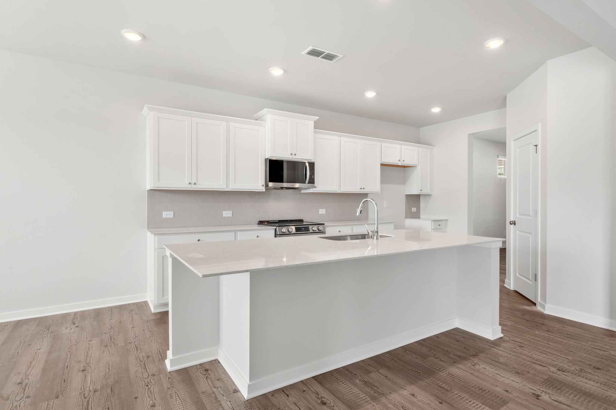 A kitchen with white cabinets.