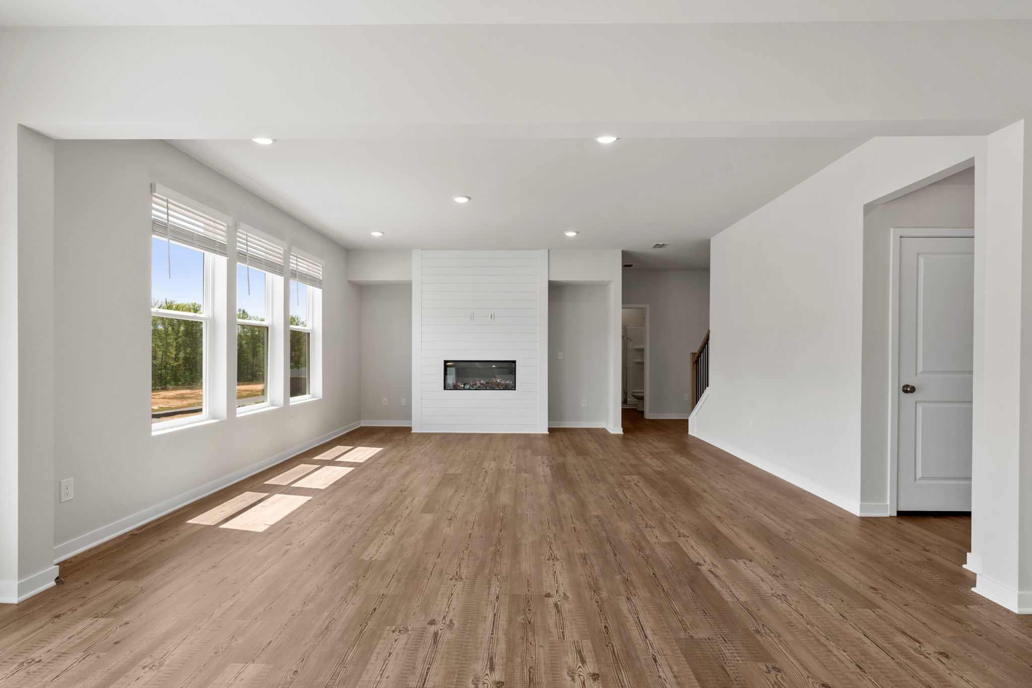 A large empty room with a wood floor and white walls.