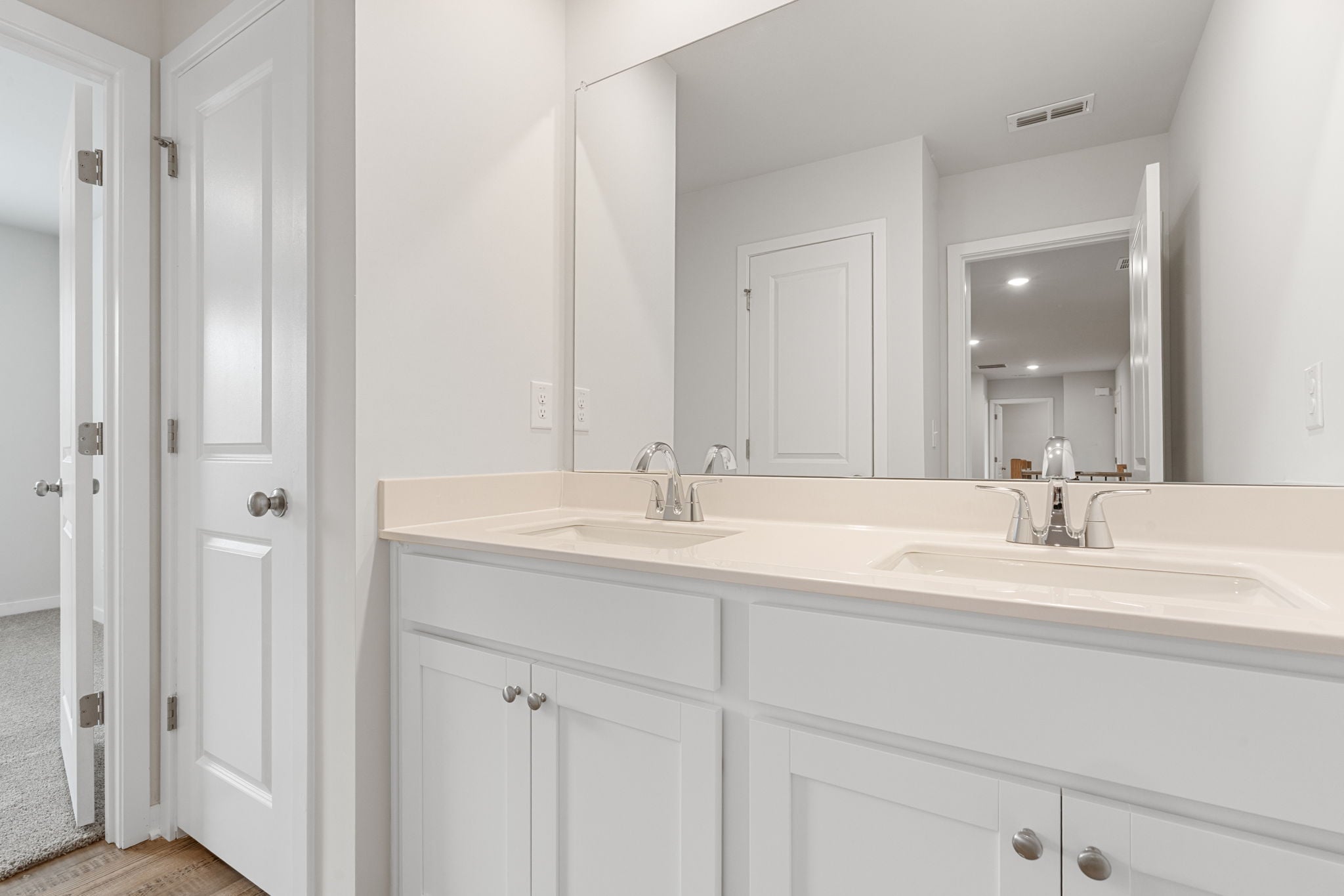 A bathroom with white cabinets.