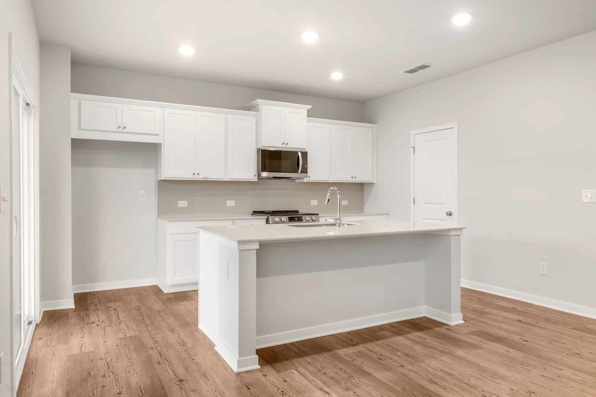 A kitchen with white cabinets.