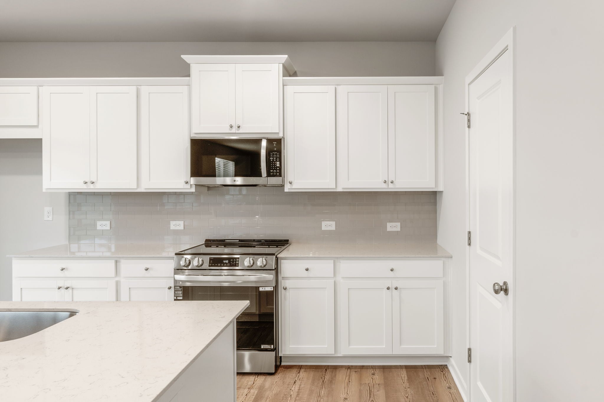 A kitchen with white cabinets.