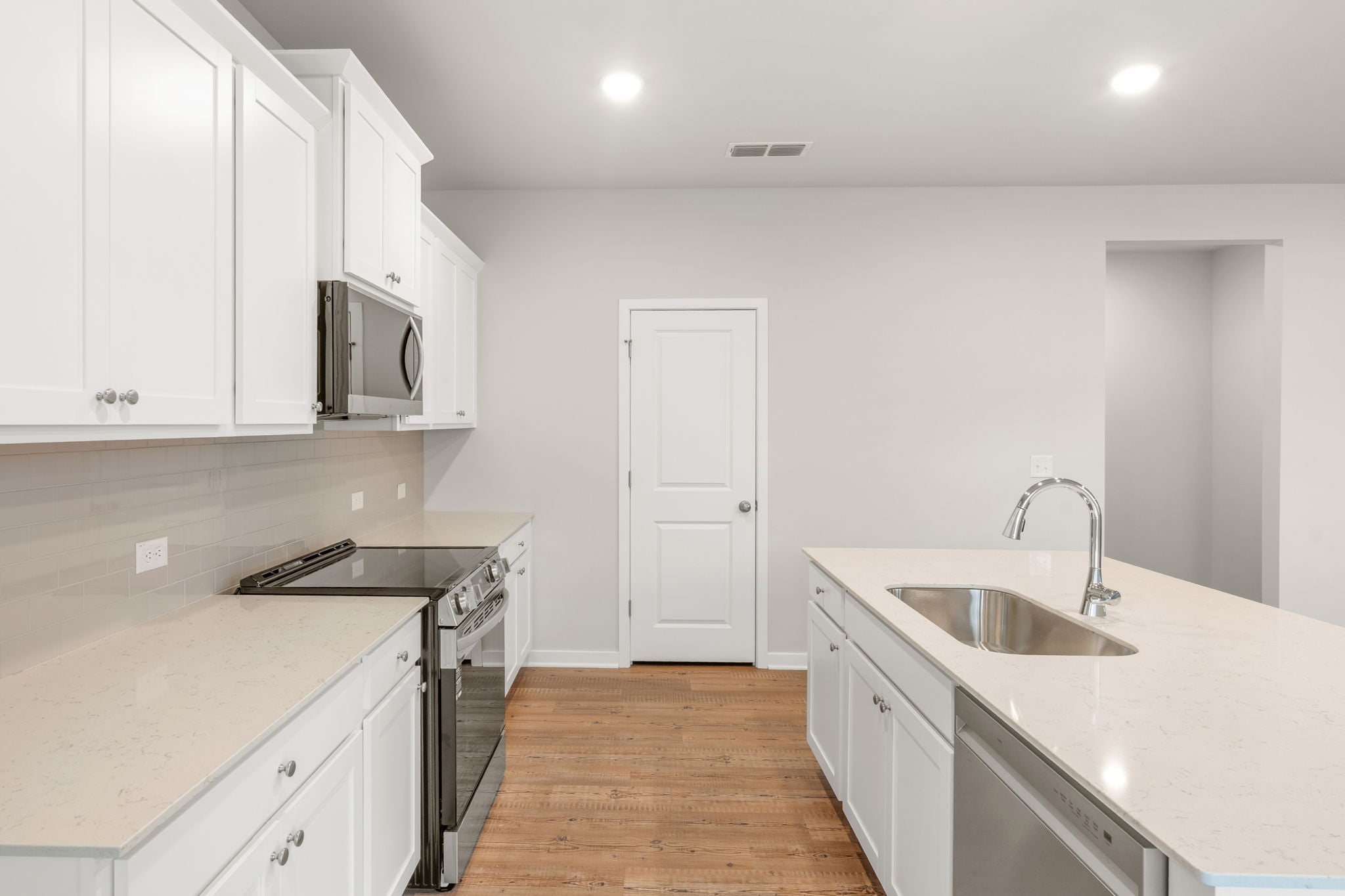 A kitchen with white cabinets.