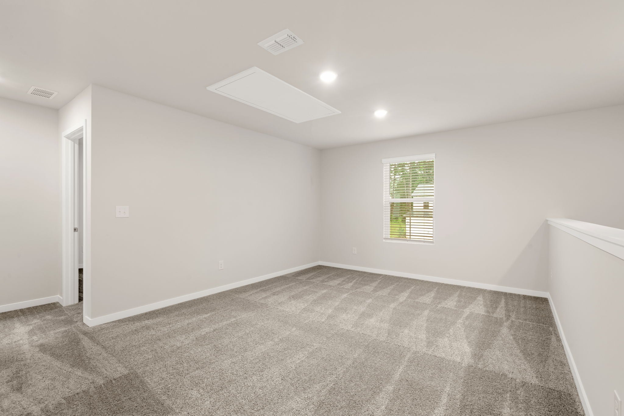 A room with a carpet and a window.