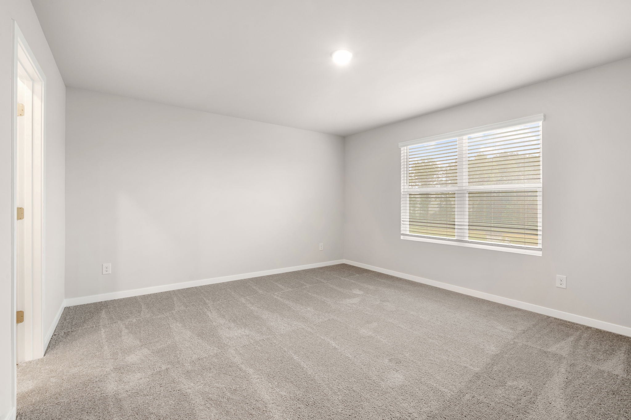 A room with a window and a carpet.