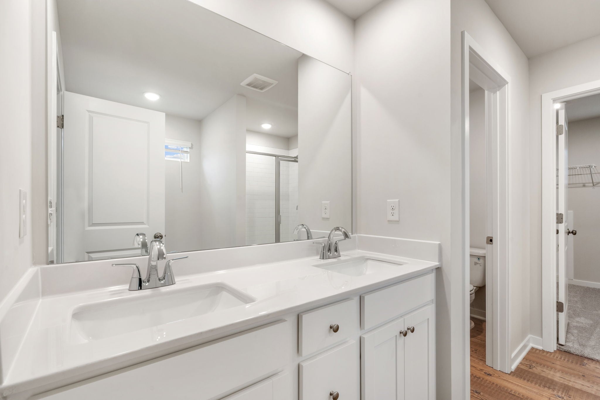 A bathroom with white cabinets.