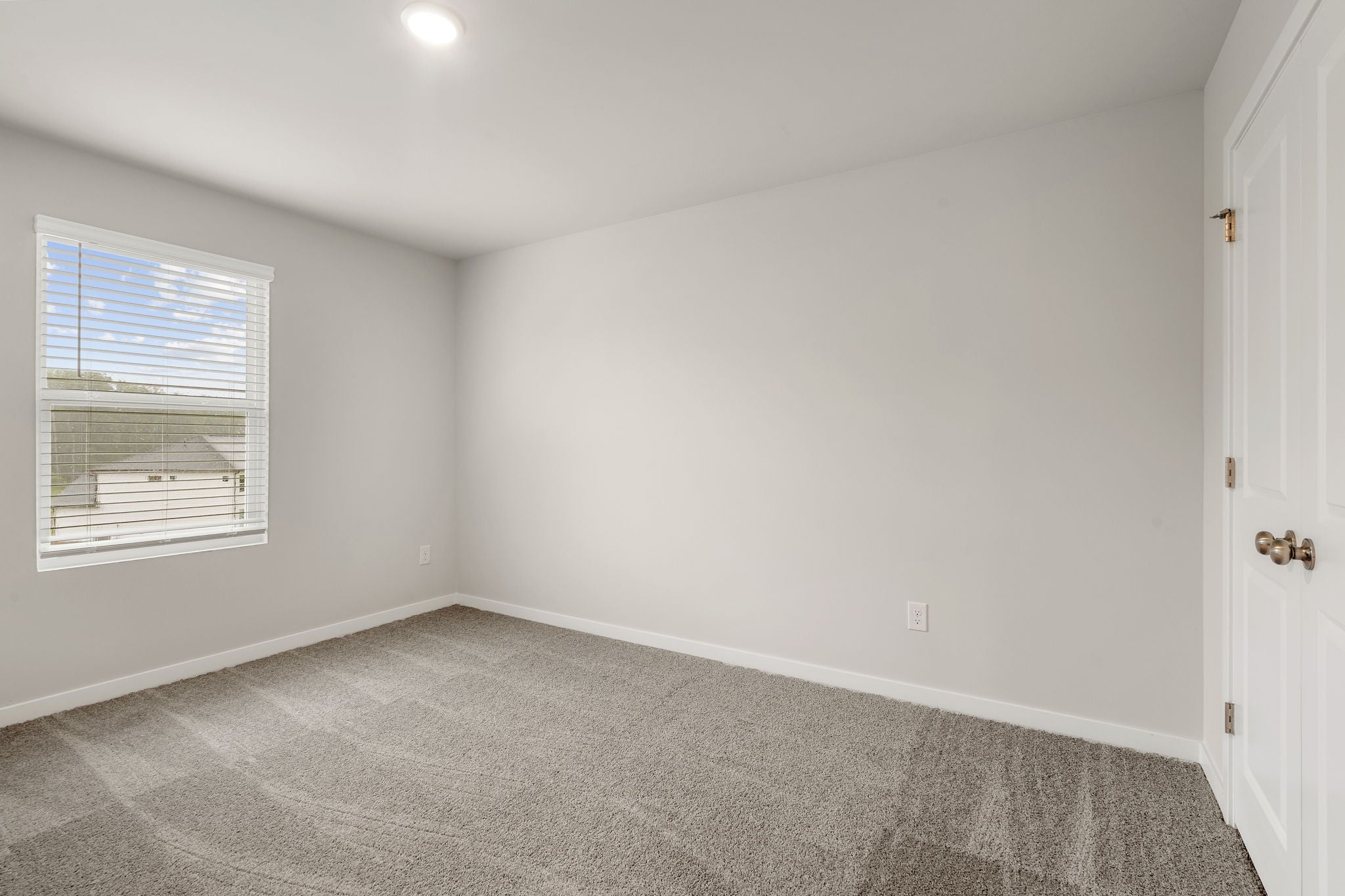 A room with a carpet and a window.