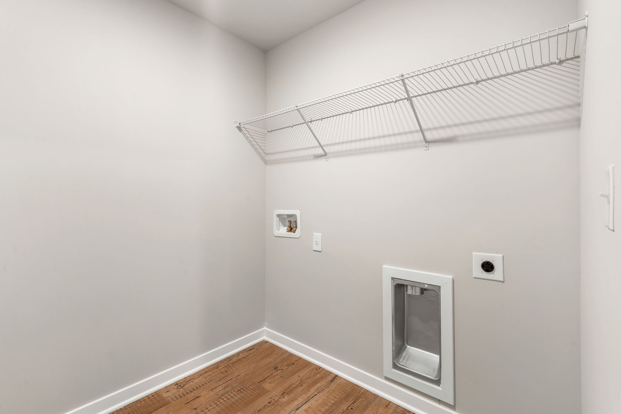 A room with a wood floor and white walls.