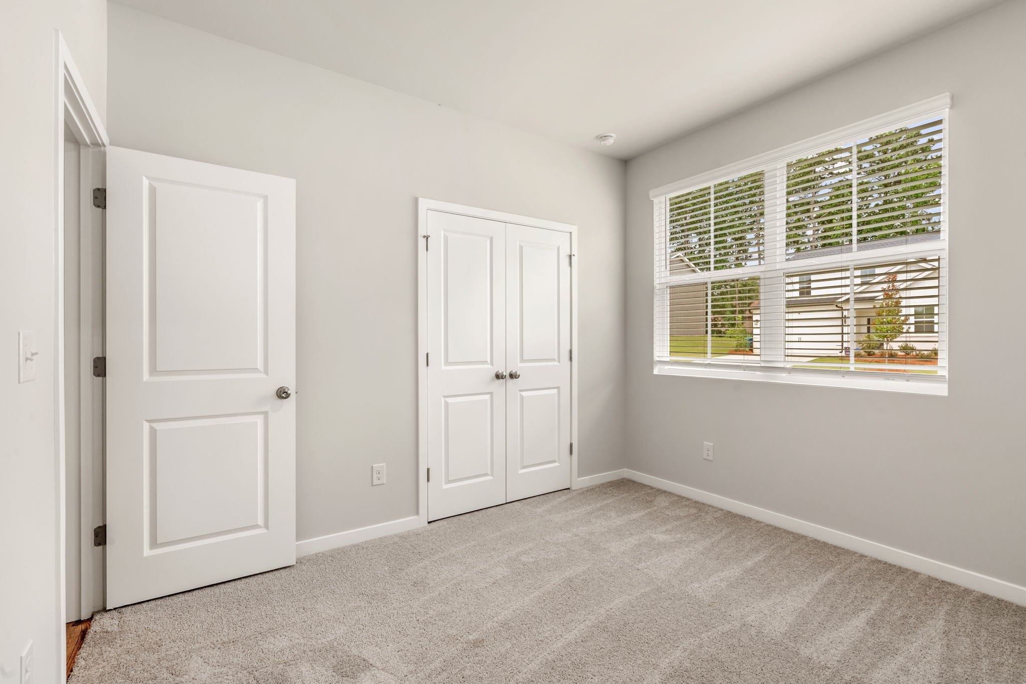 A room with white doors and a window.