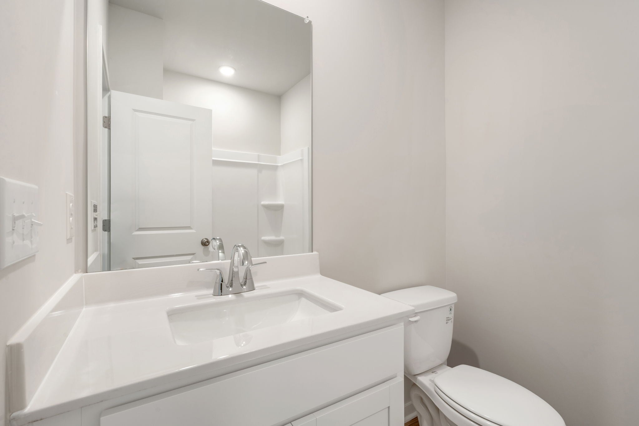 A bathroom with a sink toilet and mirror.
