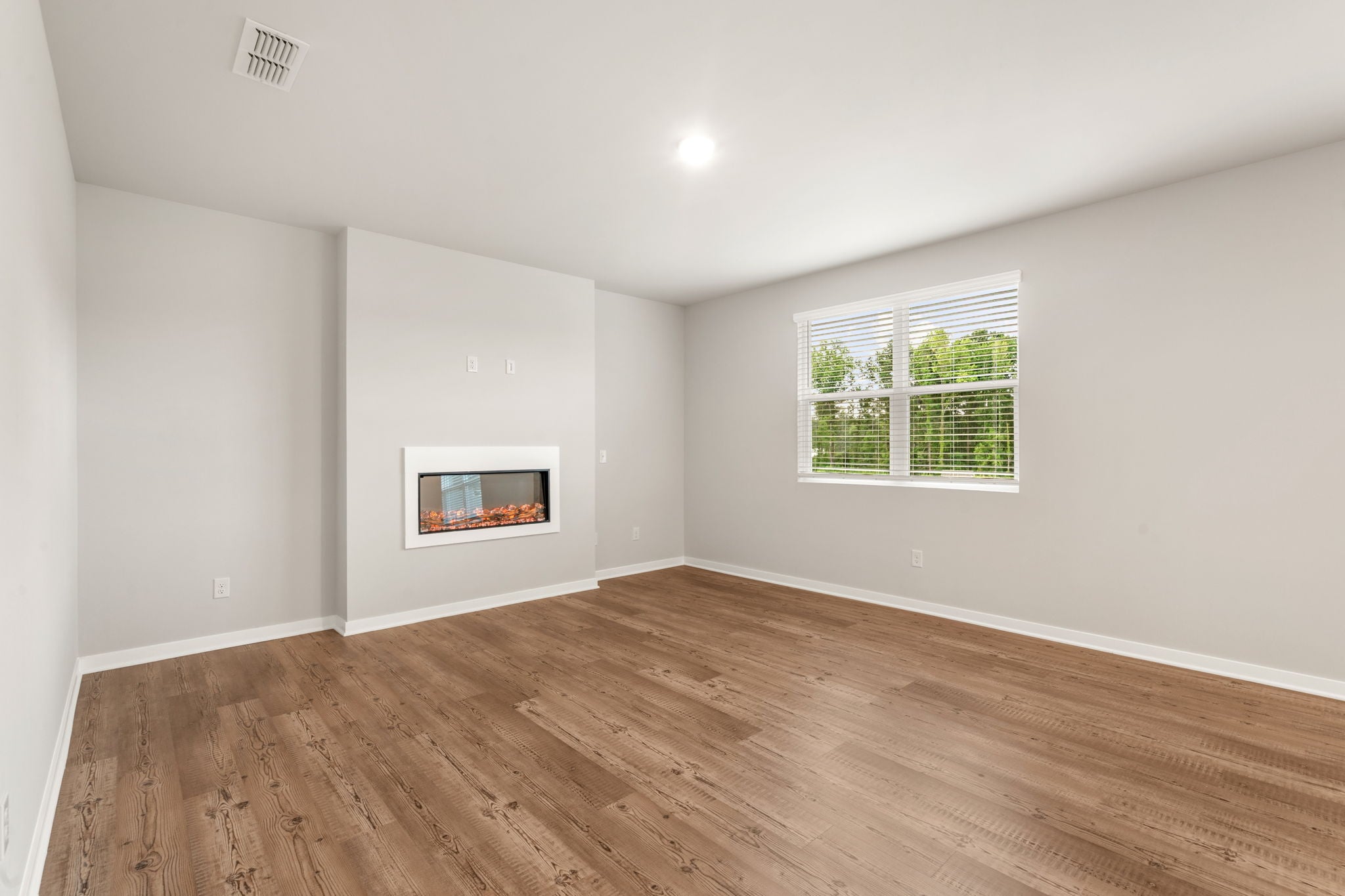 A room with a wood floor and a window.