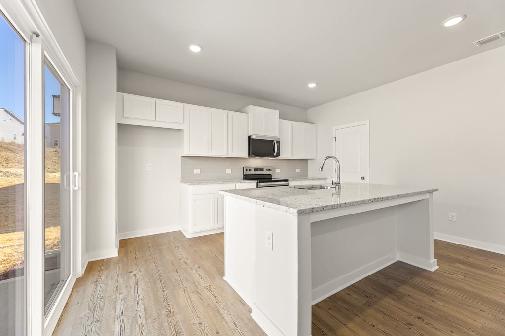 A kitchen with white cabinets.
