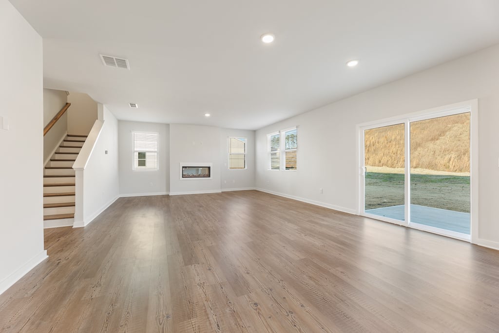 A large empty room with a wood floor and a wood floor.