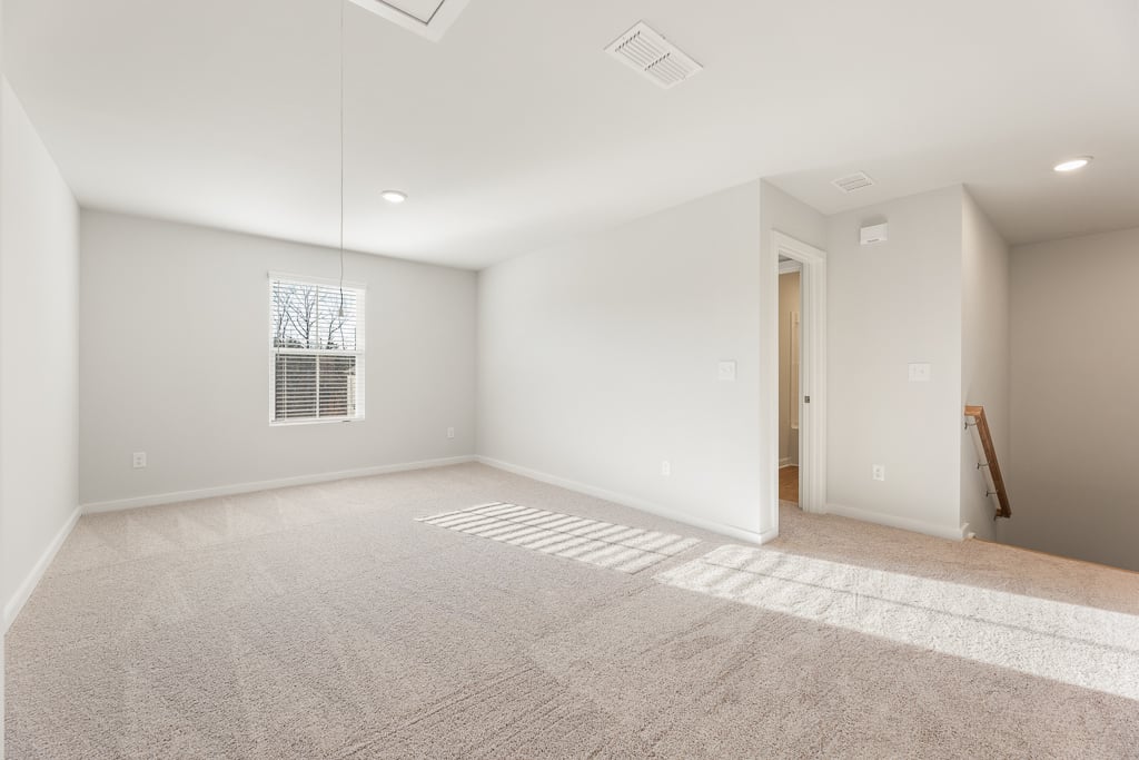 A room with a carpet and a door.